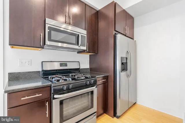 a kitchen with stainless steel appliances granite countertop a stove and a microwave