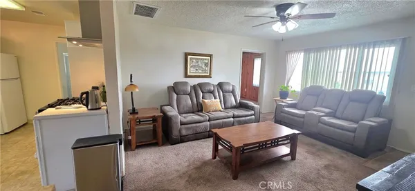 a living room with furniture ceiling fan and a window