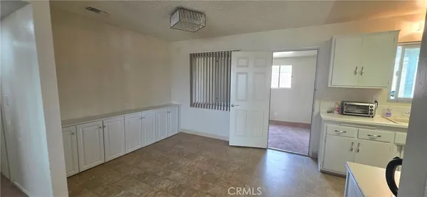 a view of a kitchen with wooden floor and cabinets
