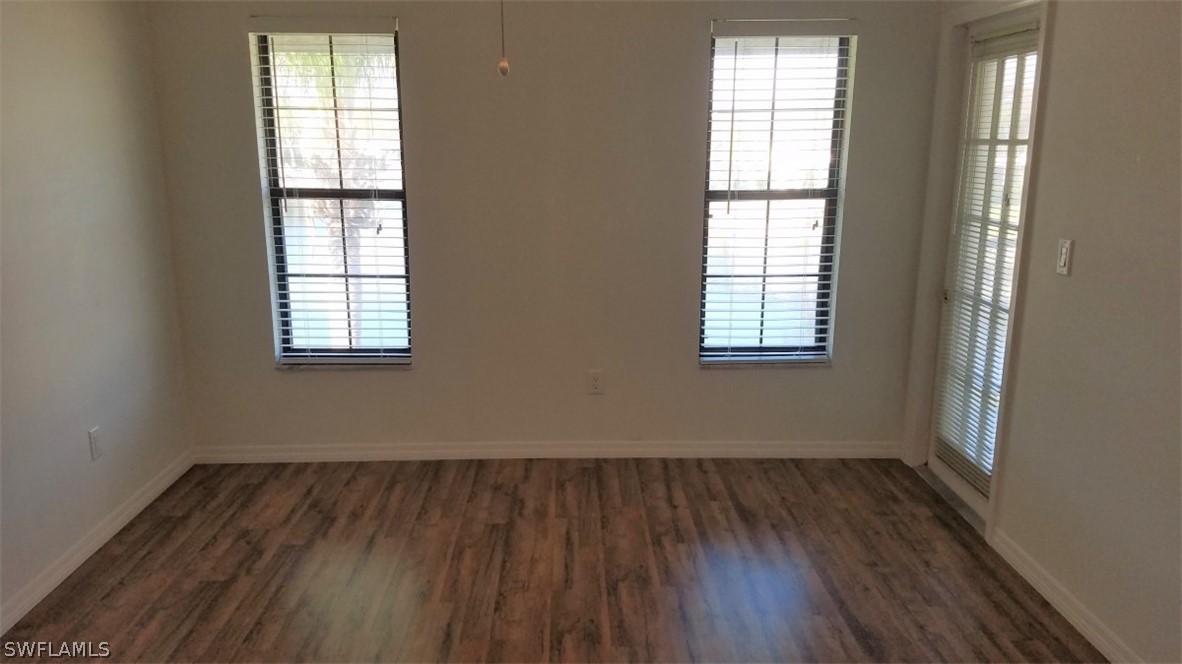 5313 Treetops Drive, Unit 202 Naples, FL 34113 - Photo 13 of 22 an empty room with wooden floor and windows