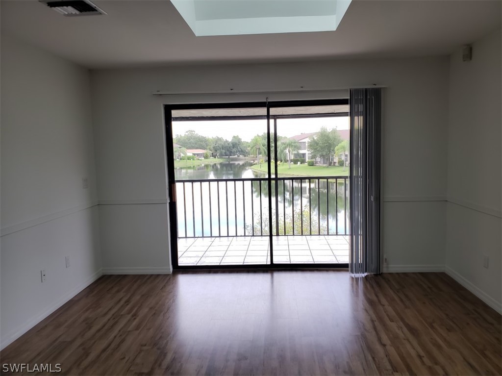 5313 Treetops Drive, Unit 202 Naples, FL 34113 - Photo 2 of 22 wooden floor in an empty room with a window