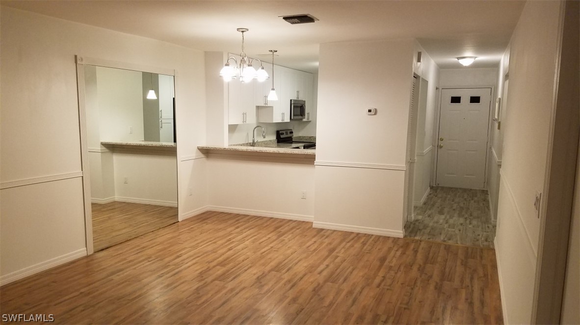 5313 Treetops Drive, Unit 202 Naples, FL 34113 - Photo 6 of 22 a view of a kitchen cabinets and wooden floor