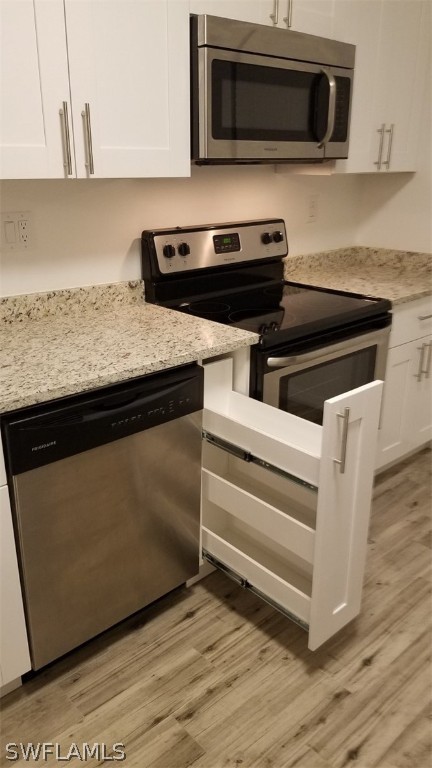 5313 Treetops Drive, Unit 202 Naples, FL 34113 - Photo 10 of 22 a kitchen with a stove and a microwave