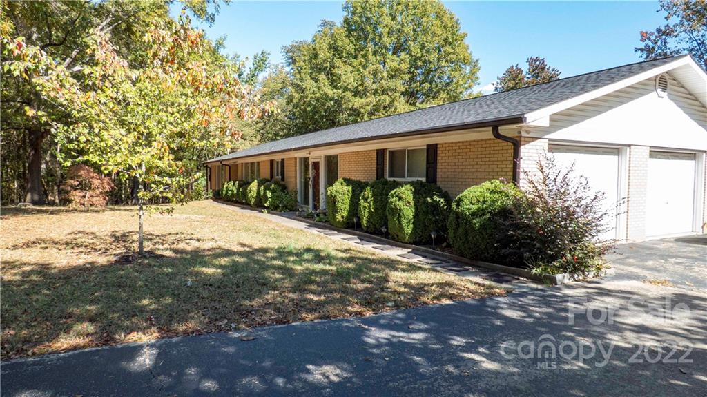 11128 Mallard Creek Road Charlotte, NC 28262 - Photo 2 of 47 a backyard of a house with large trees and outdoor space