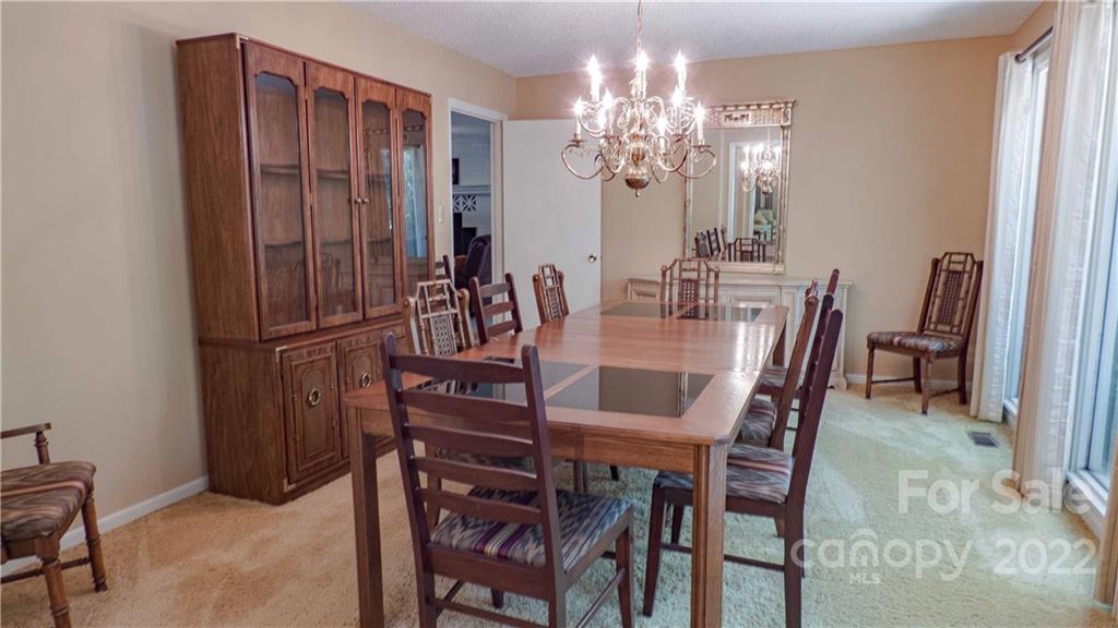 11128 Mallard Creek Road Charlotte, NC 28262 - Photo 6 of 47 a view of a dining room with furniture and chandelier