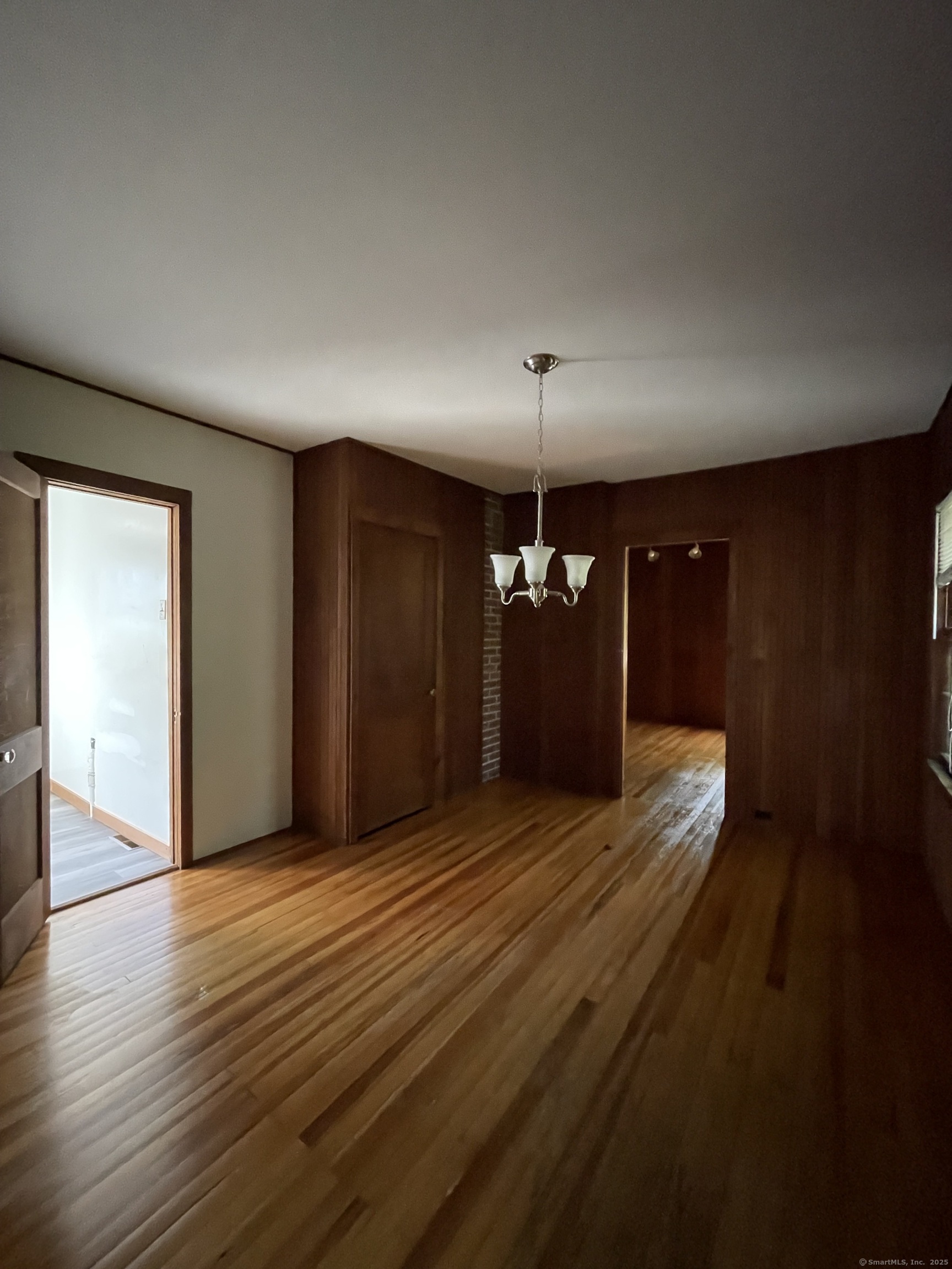 1142 Sperry Road Cheshire, CT 06410 - Photo 4 of 16 an empty room with wooden floor and chandelier