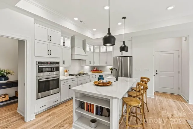 a kitchen with stainless steel appliances kitchen island granite countertop a stove a sink and a refrigerator