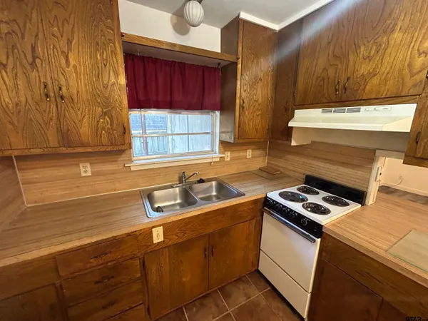 a kitchen that has a sink and a stove top oven