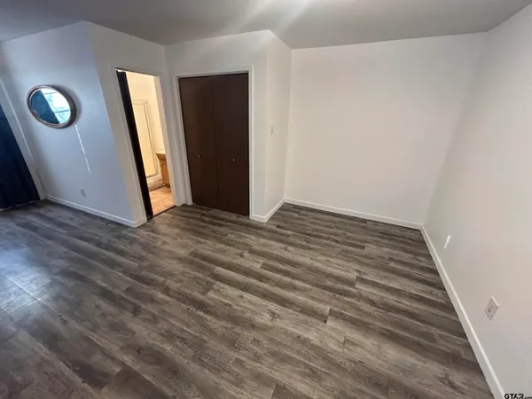 a view of an empty room with wooden floor