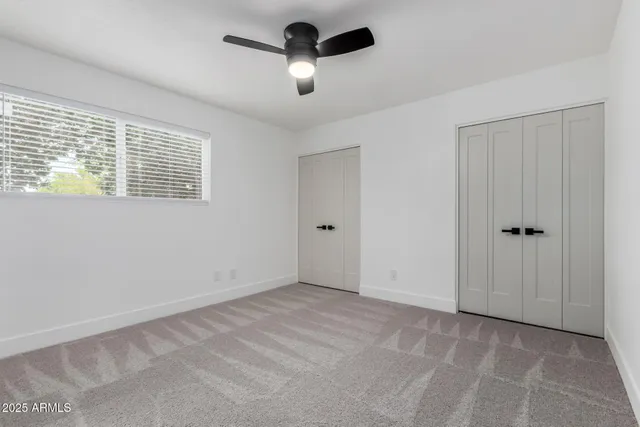 a view of an empty room with a ceiling fan