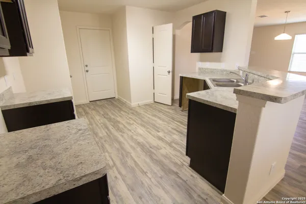 a kitchen with granite countertop a sink and a stove top oven