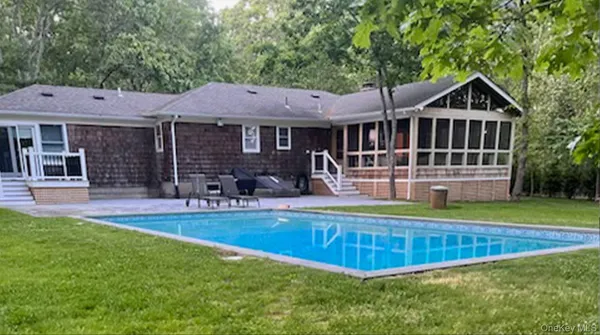 a view of a house with swimming pool and sitting area