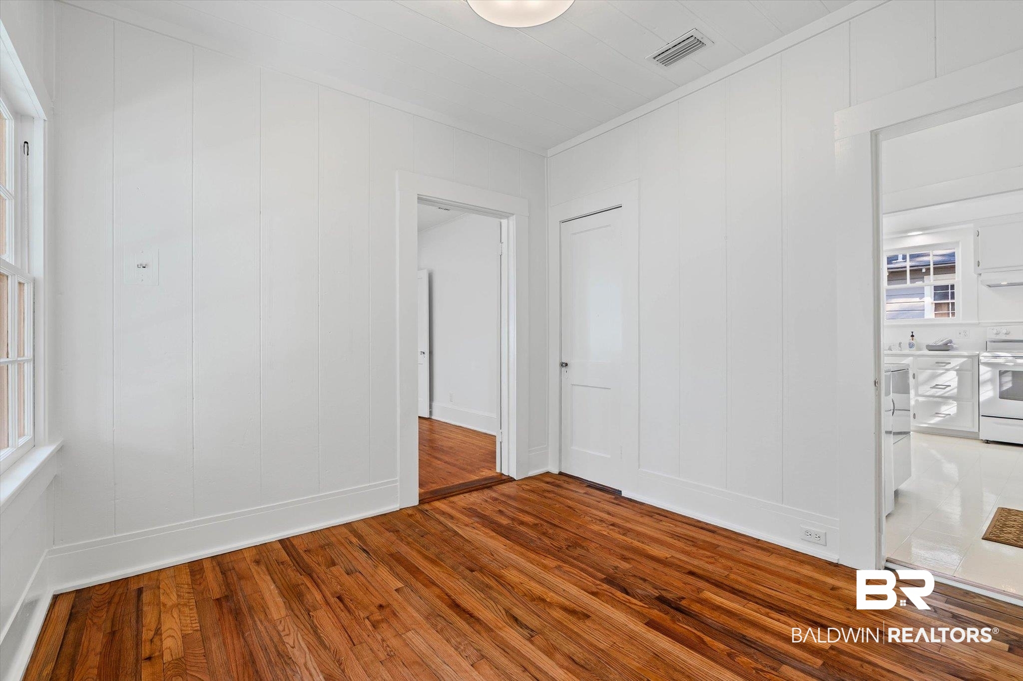 2153 Old Government Street Mobile, AL 36606 - Photo 9 of 23 Unfurnished bedroom with hardwood / wood-style floors and a decorative wall