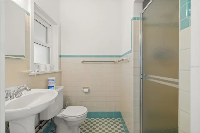 a bathroom with a sink toilet and shower