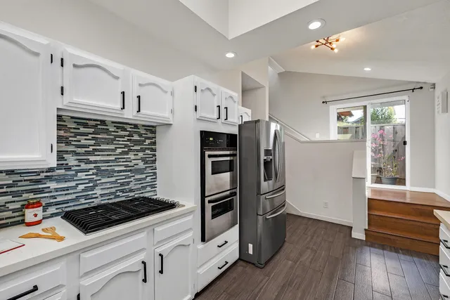 a kitchen with stainless steel appliances a refrigerator and a stove top oven