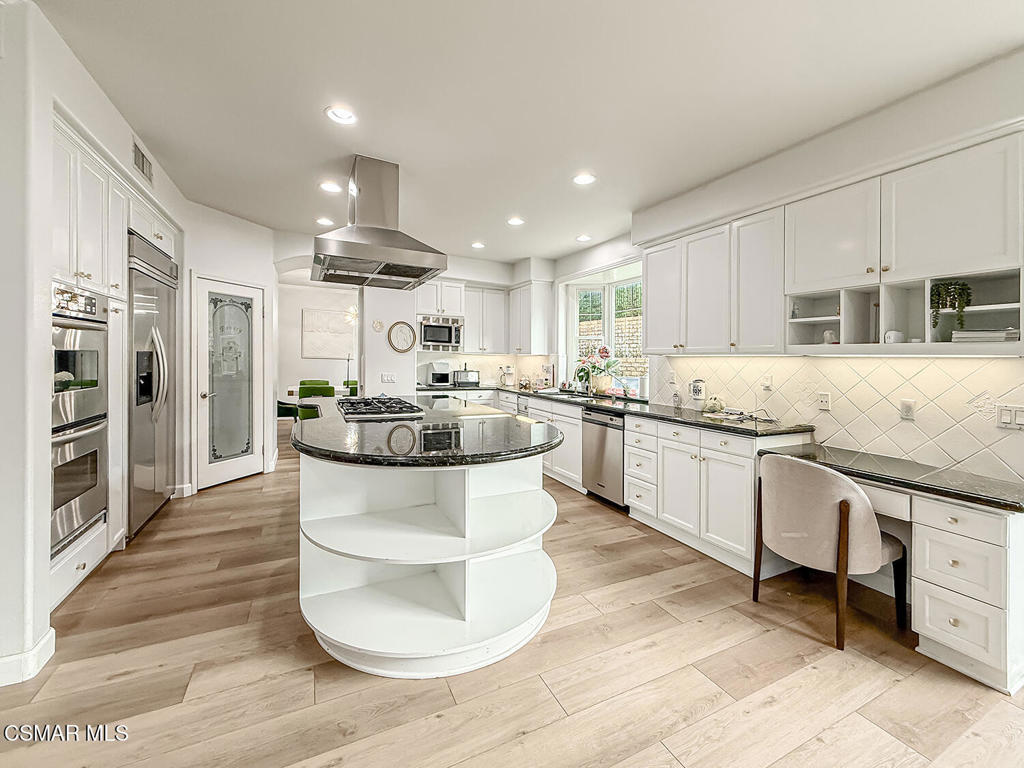 5816 Painted Pony Circle Simi Valley, CA 93063 - Photo 15 of 46 a large kitchen with stainless steel appliances kitchen island granite countertop a stove a sink a refrigerator and white cabinets