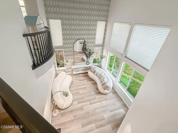 a view of a hallway with wooden floor and windows