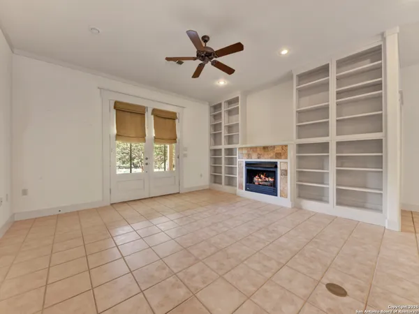 an empty room with windows and fan