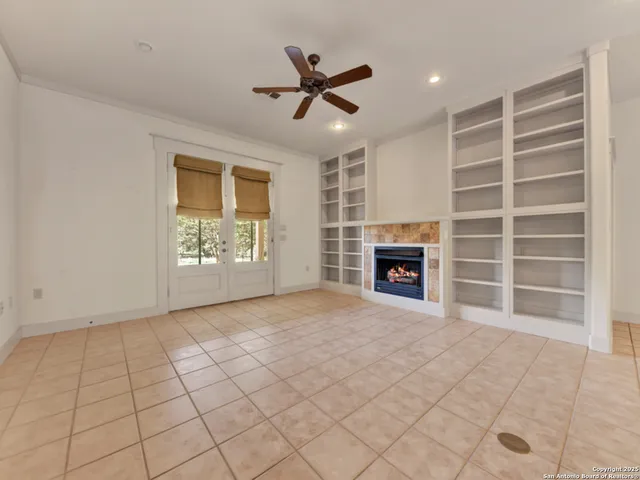 an empty room with windows and fan