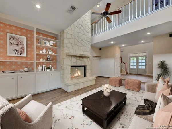 an empty room with wooden floor fireplace and windows