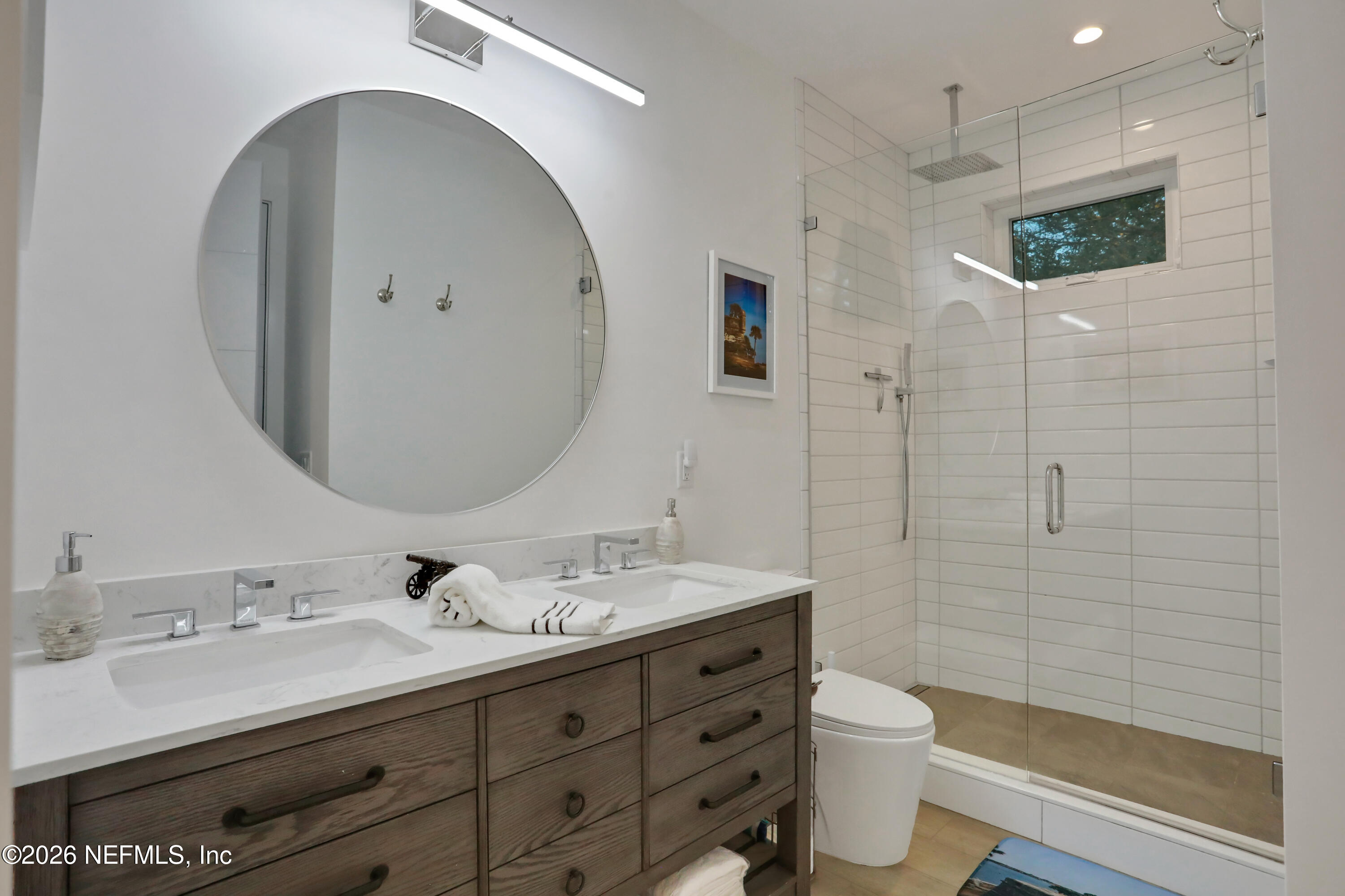 143 Washington Street St. Augustine, FL 32084 - Photo 44 of 76 a bathroom with a double vanity sink toilet and shower
