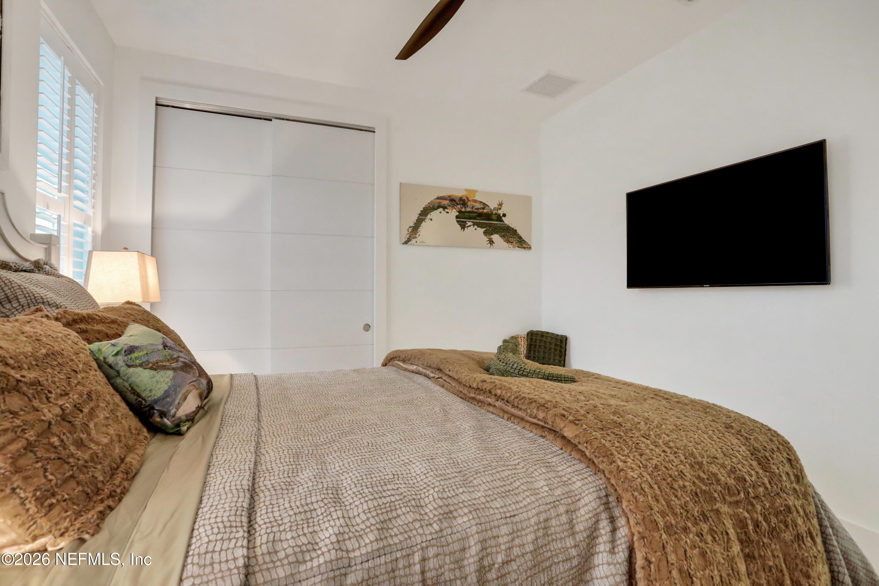 143 Washington Street St. Augustine, FL 32084 - Photo 46 of 76 a bedroom with a bed and a flat screen tv
