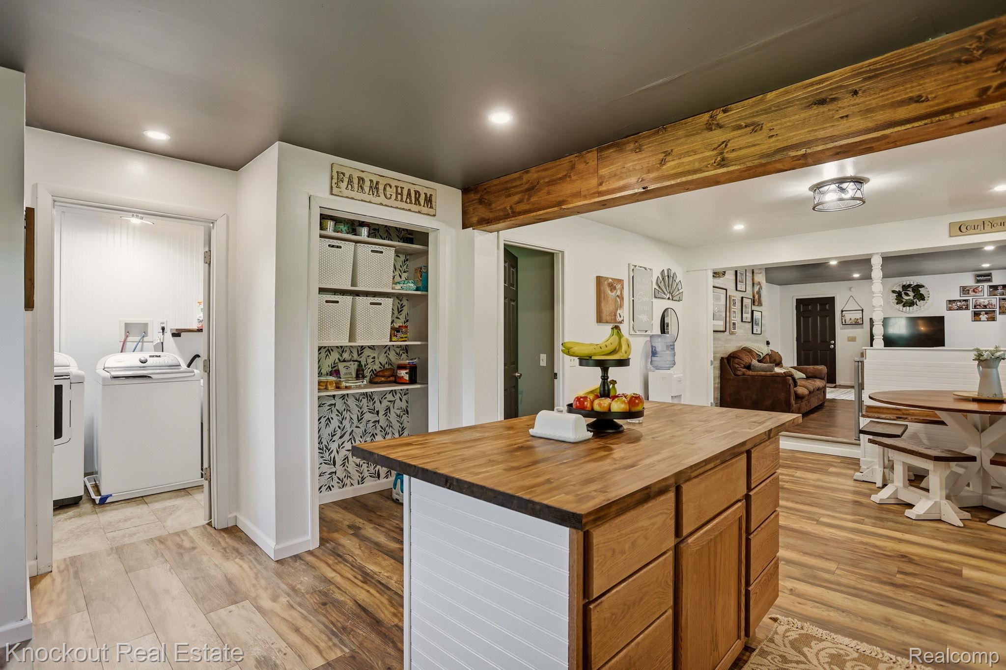 8845 Ormes Road Vassar, MI 48768 - Photo 15 of 35 Kitchen island featuring a wood-finish countertop, white paneling, and wood-finish cabinetry
