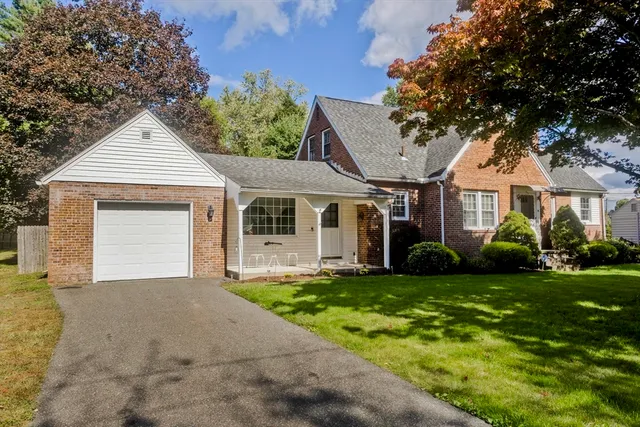 a front view of a house with a garden and yard