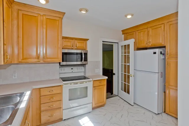 a kitchen with white cabinets and stainless steel appliances