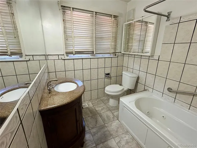 a bathroom with a granite countertop sink and a bathtub