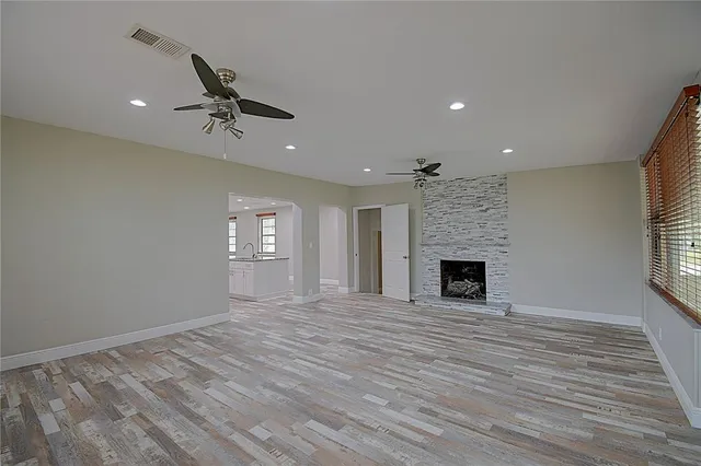 a view of an empty room with window and fire place
