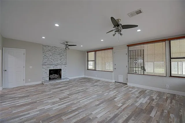a view of an empty room with a window and fireplace