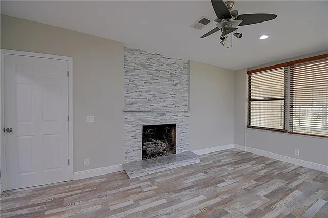 a view of an empty room with a window and fireplace