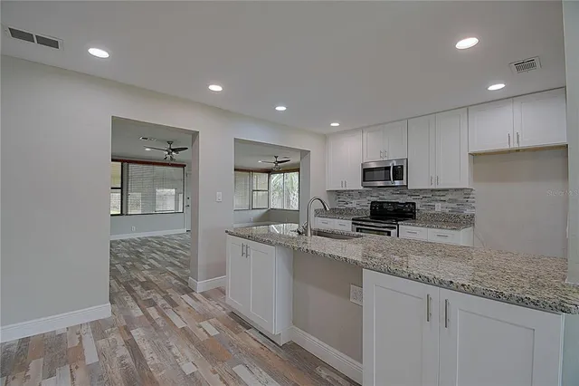 a kitchen with stainless steel appliances granite countertop a sink stove and refrigerator