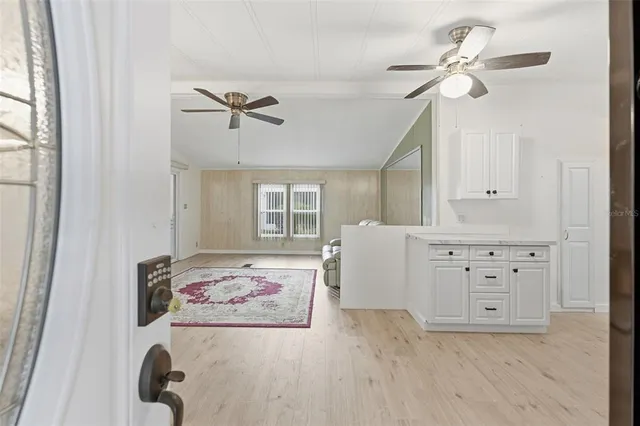 a hallway with a chandelier fan and a window