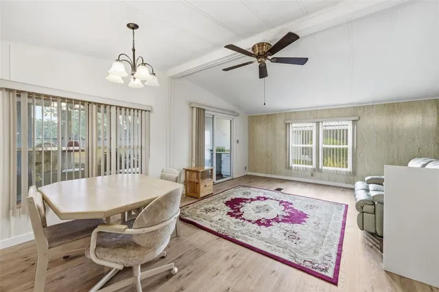 a living room with a dining table and a chandelier