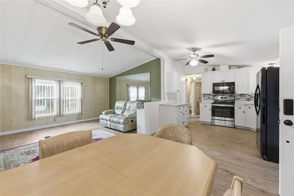 a bedroom with a bed a chandelier and flat screen tv