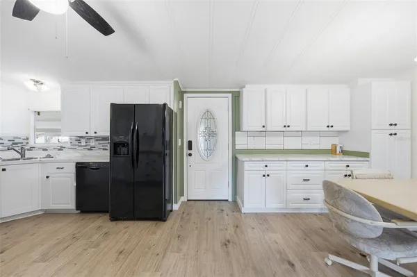 a kitchen with a refrigerator and white cabinets