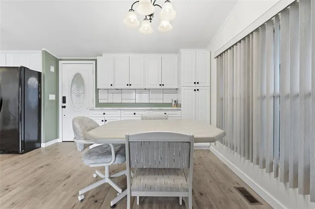 a kitchen with stainless steel appliances a table and chairs in it