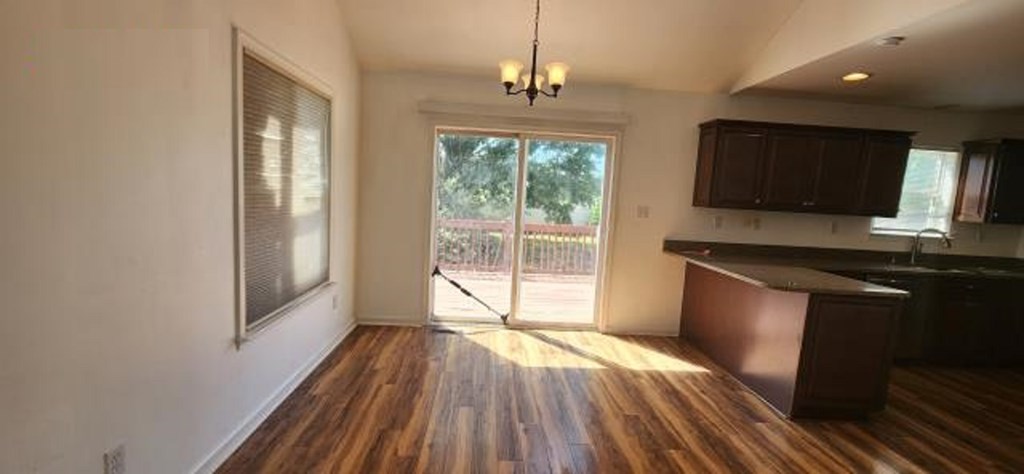 2402 Octopus Road Greenbackville, VA 23356 - Photo 4 of 21 a kitchen with granite countertop wooden floors a sink and a window