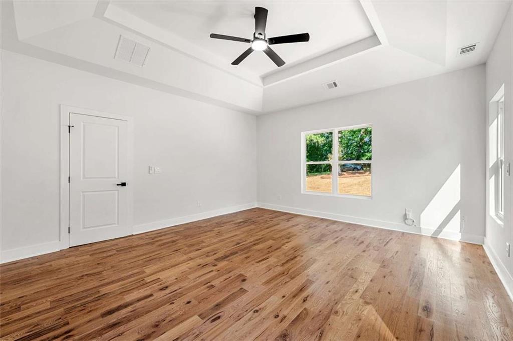 1606 Blvd Lorraine Southwest Atlanta, GA 30311 - Photo 20 of 24 a view of empty room with wooden floor and fan