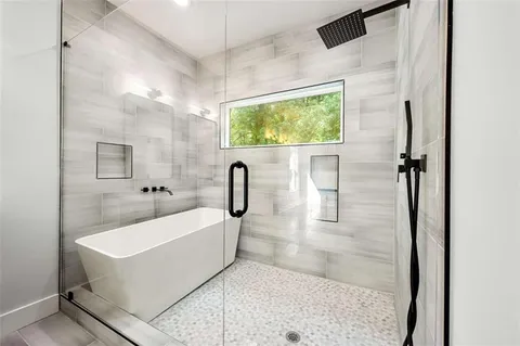 a spacious bathroom with a bathtub and mirror