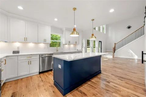 a kitchen with kitchen island granite countertop a sink and a stove