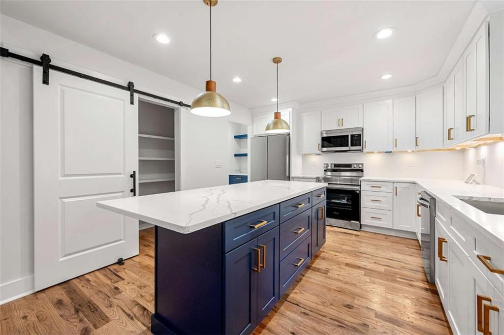 1606 Blvd Lorraine Southwest Atlanta, GA 30311 - Photo 6 of 24 a kitchen with kitchen island granite countertop a sink a counter top space stainless steel appliances and cabinets