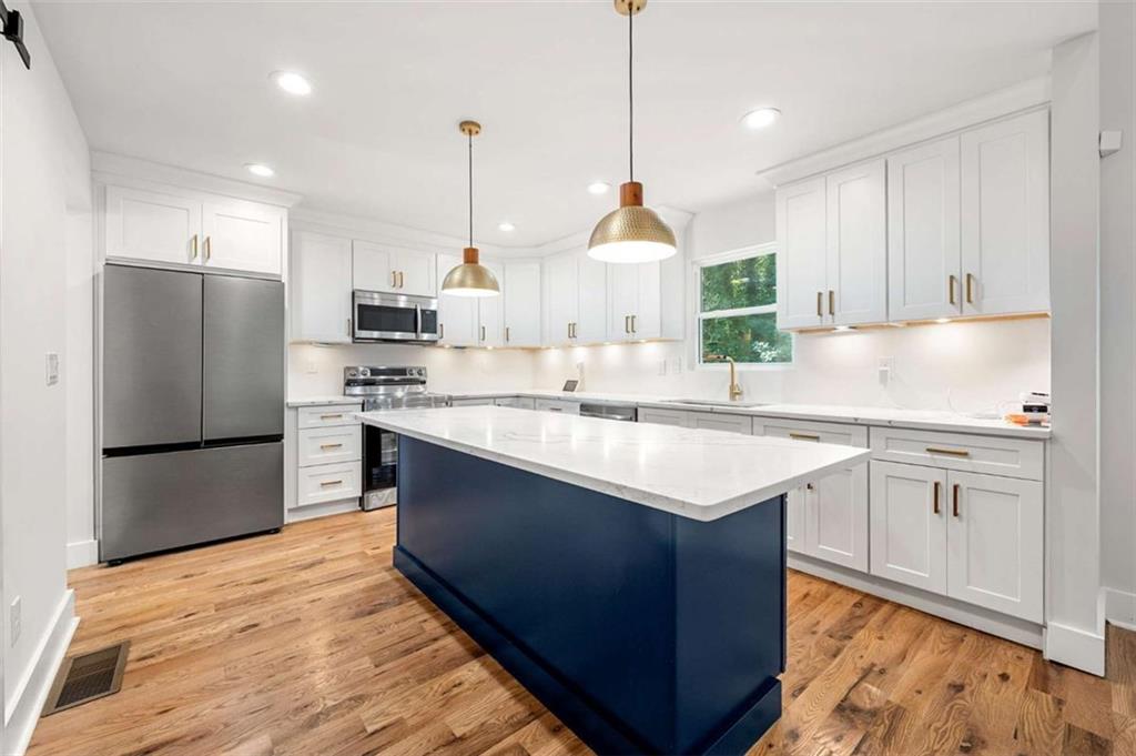 1606 Blvd Lorraine Southwest Atlanta, GA 30311 - Photo 7 of 24 a kitchen with kitchen island a sink stainless steel appliances and refrigerator