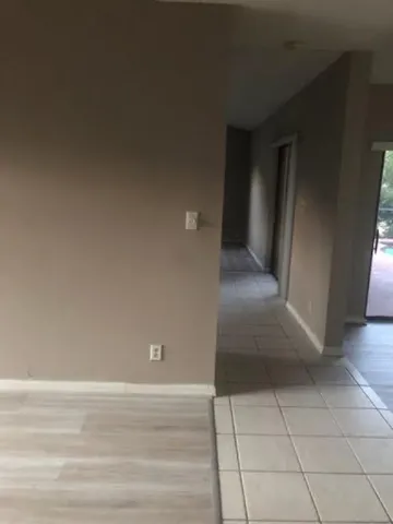 a view of a livingroom with an empty space and a hallway