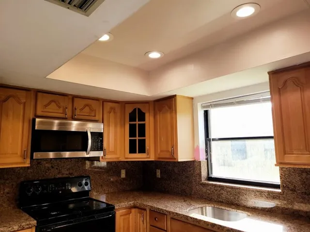 a kitchen with a large window in it and a flat screen tv
