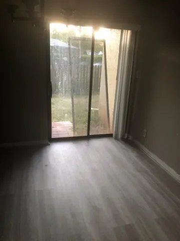 a view of a room with wooden floor and window