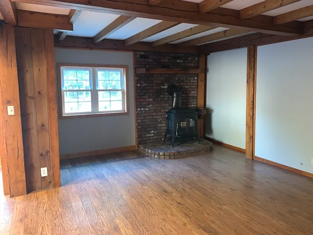 an empty room with wooden floor and a window