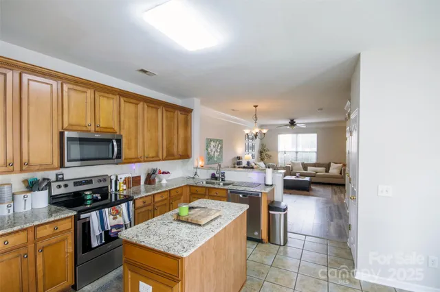 a kitchen with a stove a sink a microwave a dining table and chairs